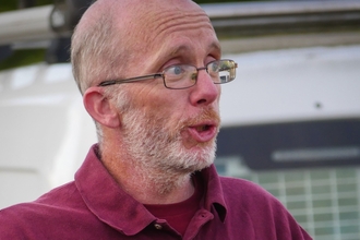 Close up of Iain Webb speaking to a group about chalk, cheese and glow worms