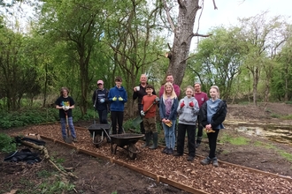 Group of young volunteers stand with Wildlife Trust staff on a newly laid path