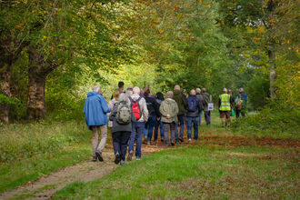 A group of members walking through a woodland trail