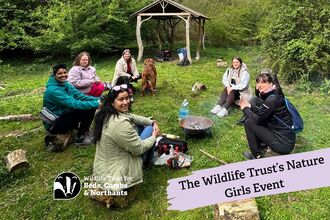 group of women sitting around fire bowl
