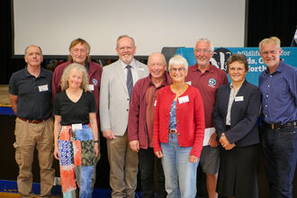 A group of the award winners stand beside CEO Brian Eversham, Vice President professor William Stephens and Trustee Chair Dr Hilary Alison at the AGM