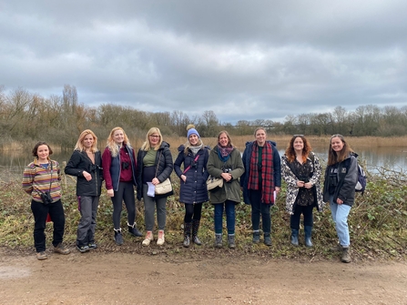 Group of girls standing next to a lake